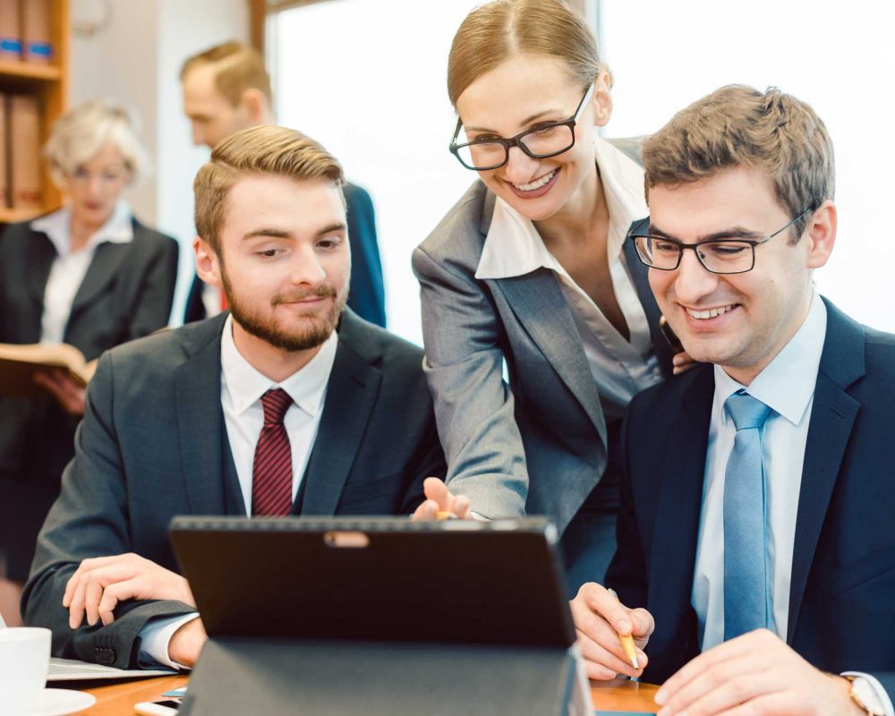 Lawyers in their law firm working on computer with books in background