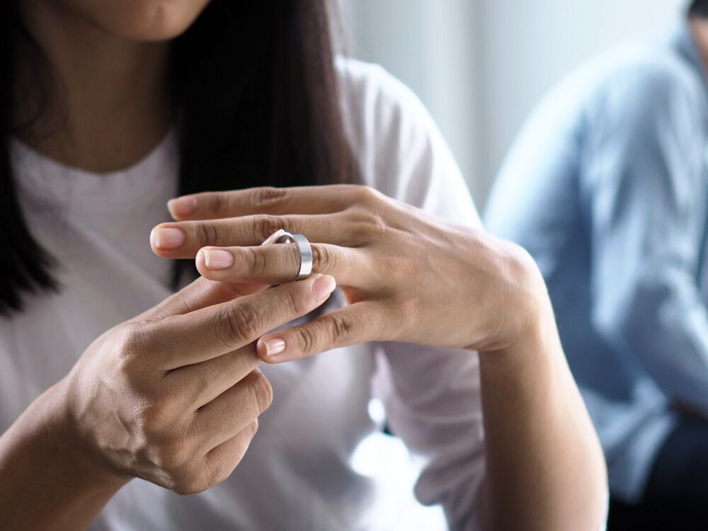 Woman removing wedding ring during divorce process