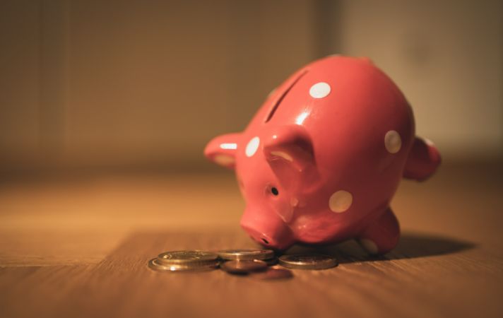 tilted piggy bank to signify paying a deposit